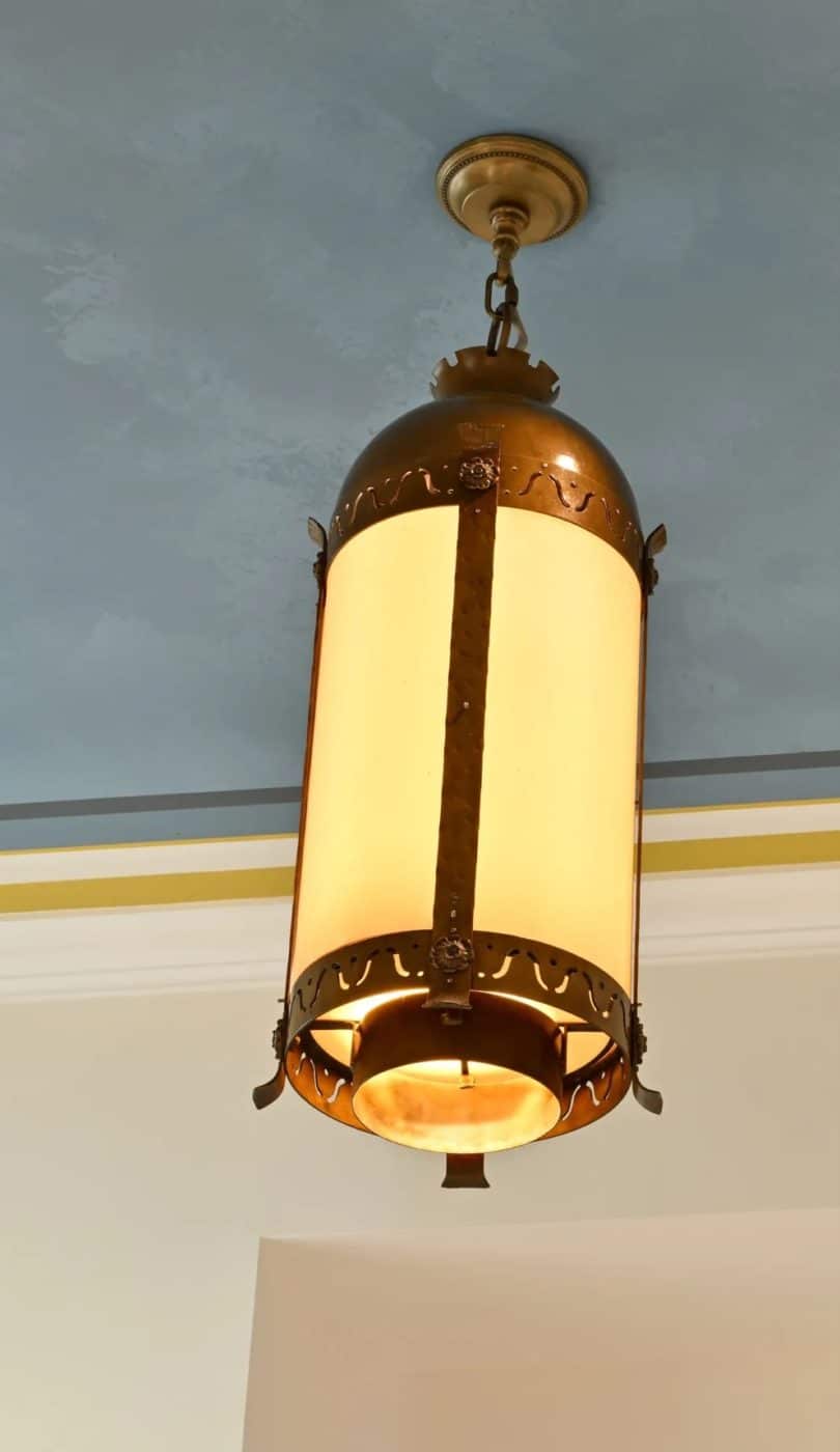 A single lit lantern hanging down from the wall